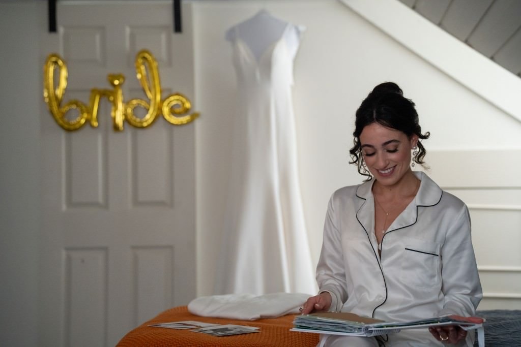 Bride to be in pajamas enjoys a moment with a magazine before getting ready on her wedding day.jpg