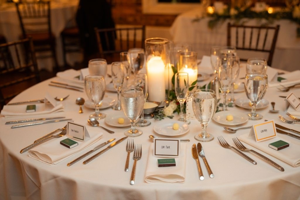 Elegant table setting with candles glassware silverware and place cards for a formal event.jpg