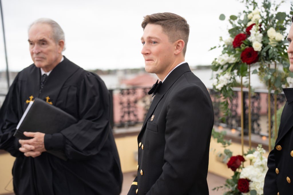 Groom tearing up as he waits at the altar next to officiant.jpg
