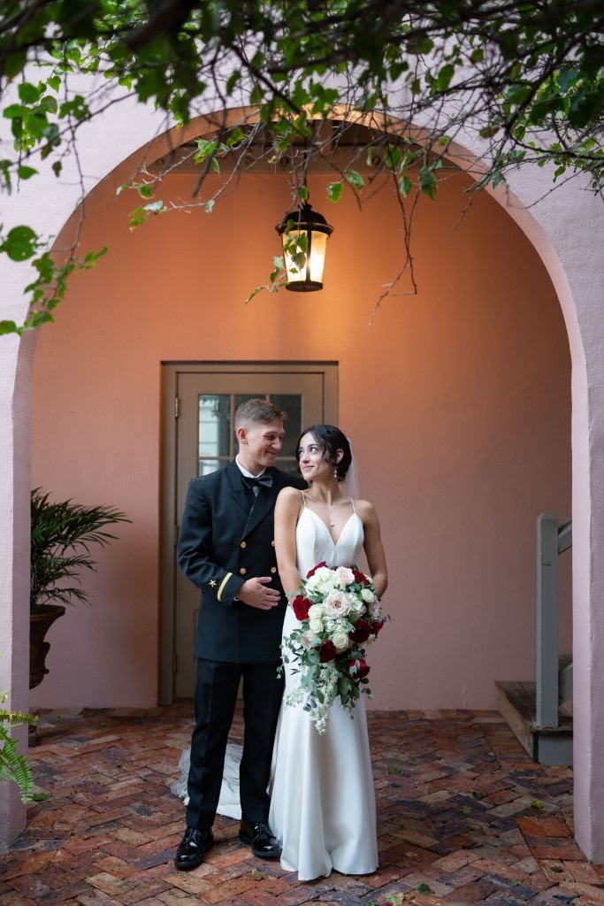 Newlyweds share a joyful moment under a lantern with the bride holding a bouquet.jpg