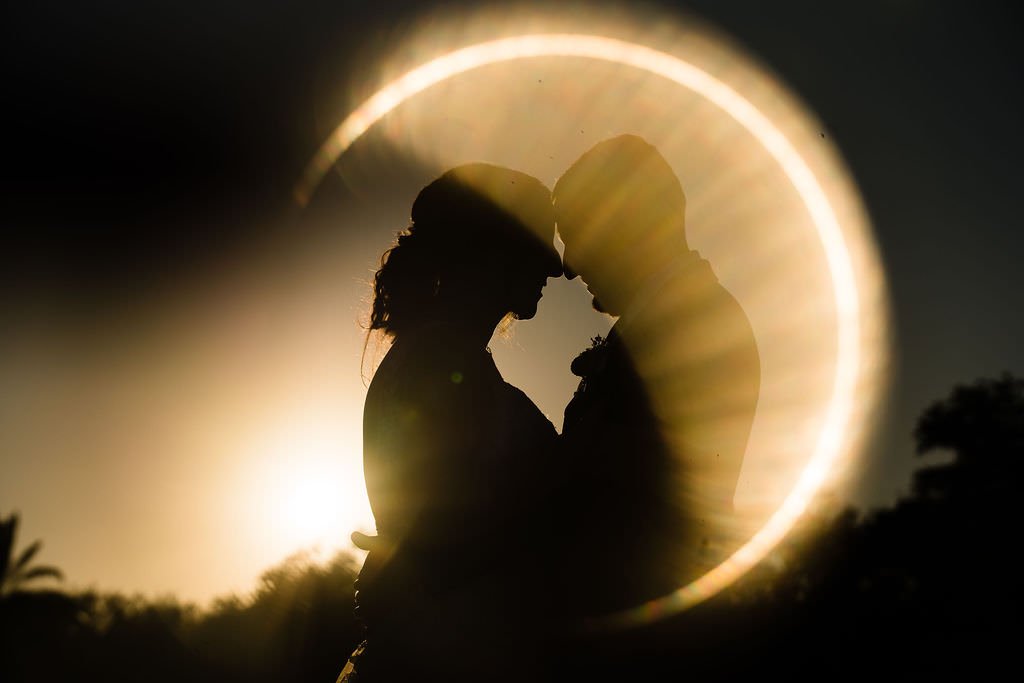 Silhouettes of a couple embraced bathed in the golden glow of the sunset.jpg
