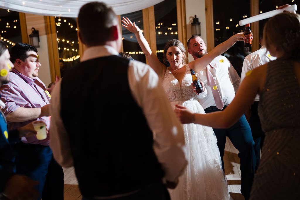 The bride and groom are dancing with their guests at their wedding reception The party is in full swing.jpg