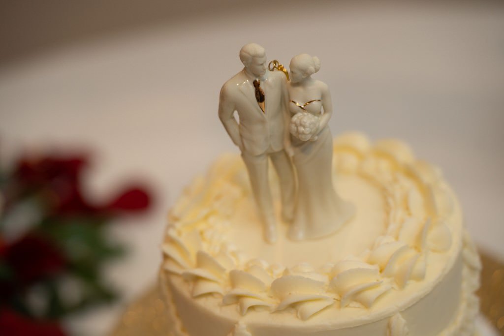 Wedding cake topped with a bride and groom figurine.jpg