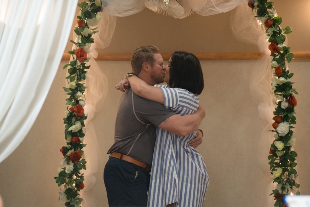 Couples first kiss under floral arch.jpg