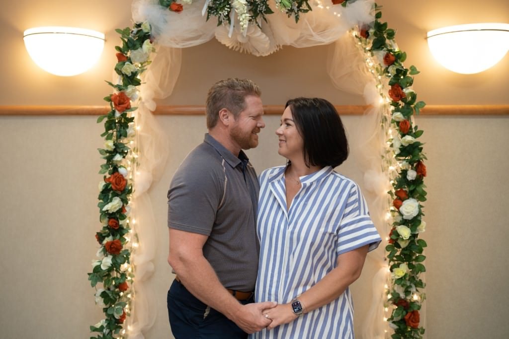 Couple under floral wedding arch.jpg