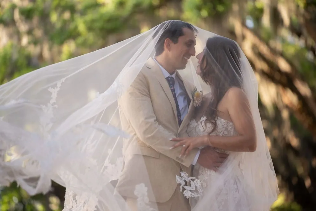 bride and groom under veil with oak trees