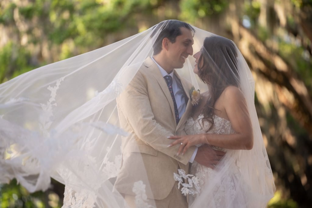 bride and groom under veil with oak trees