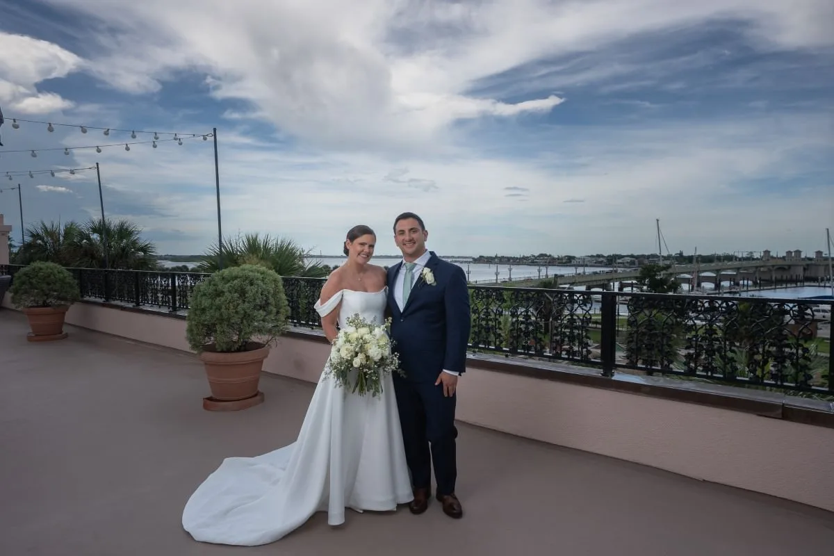 a groom and bride posing on the rooftop of the white room